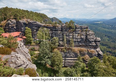 Beautiful Landscape With Pravcicka Brana Rock Formation, Falcons Nest Hotel And Forest In Czech Repu