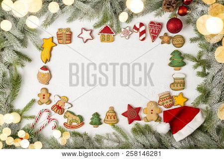 Table Top Shot Of A Frame Made Of Fir Branches, Decorated With Candy Cane And Santa Hat, With Christ
