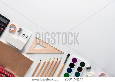 Top View Over A Notebooks, Paints, Pencils, Rulers, Paper Clips, Pins, Stepler, Glue, Sharpener, Pen