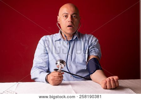Hypertensive Patient Performing A Blood Pressure Auto Test / Man Self-monitoring Of Blood Pressure W