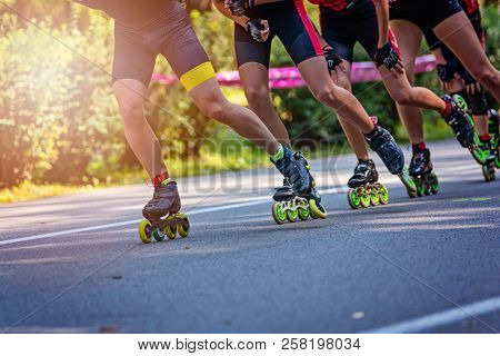Inline Roller Skaters Racing In The Park On Asphalt Road