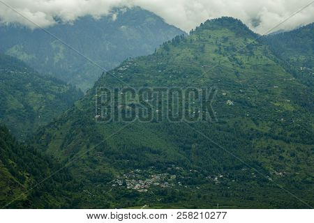 Villages In Green Mountains Slope And Clouds