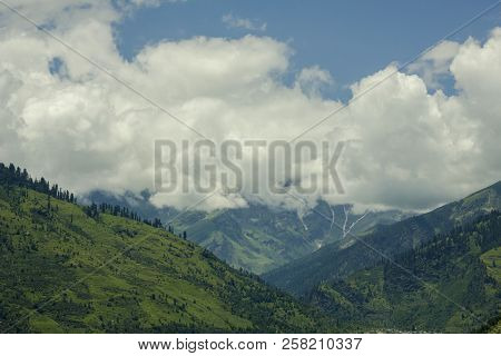 Wooded Hills In A Mountain Valley And Clouds