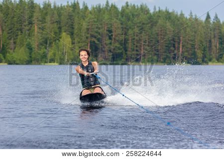 Young Athletic Woman Riding Kneeboard On A Lake