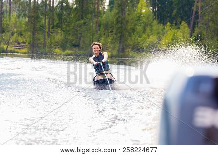 Young Athletic Woman Riding Kneeboard On A Lake