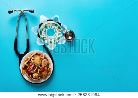 Studio Shoot Chinese Herb Medicine And Pills Wrapped With A Stethoscope On Blue Background With Copy