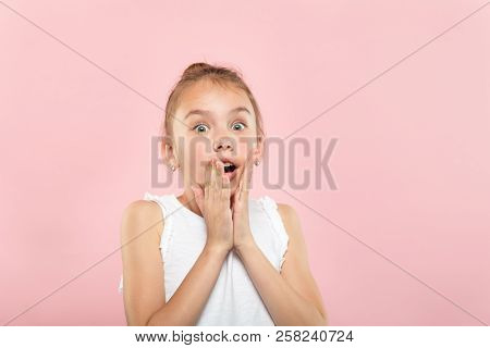 Speechless Dumbstruck Shocked Gasping Little Girl. Portrait Of A Young Cute Child On Pink Background