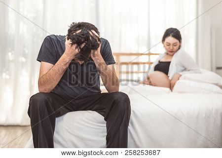 Worried Stress Man Sitting On Bed With Hand On Forehead In Bedroom In Serious Mood Emotion With Preg