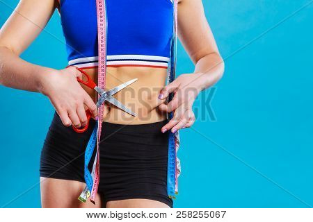 Weight Gain Diet Liposuction Concept. Woman With Measure Tapes Pinches In The Fat At The Waist, Hold