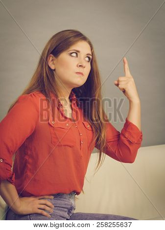 Angry, Pissed Off Young Woman. Attractive Female With Long Brown Hair Sitting On Sofa Being Mad And 