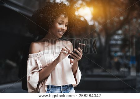 Charming Cheerful African-american Female With Cellphone On A Summer City Street; Cute Brazilian Wom