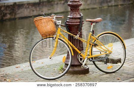 Yellow Bike Near City Street Pole. Bruges, Belgium