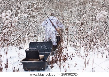 Snowmobile Hunter Rides Through The Winter Forest
