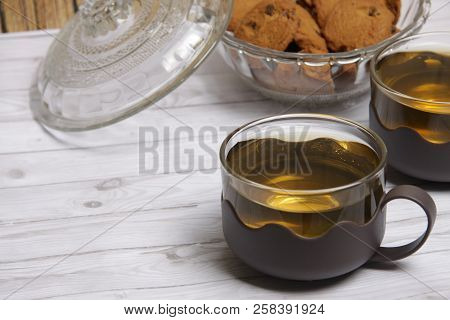 Two Cups Of Green Tea With Choco Chips Cookies On White Wooden Table