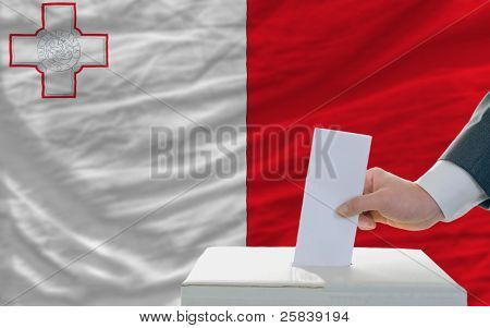 Muž hlasování o volbách na Maltě před vlajkou