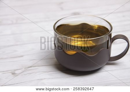 A Cup Of Green Tea With On White Wooden Table