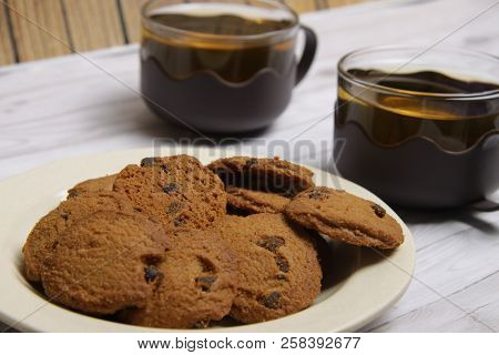 Two Cups Of Green Tea With Choco Chips Cookies On White Wooden Table