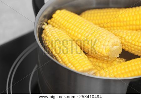 Stewpot With Water And Corn Cobs On Stove, Closeup
