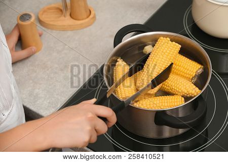 Woman Preparing Corn In Stewpot On Stove, Closeup