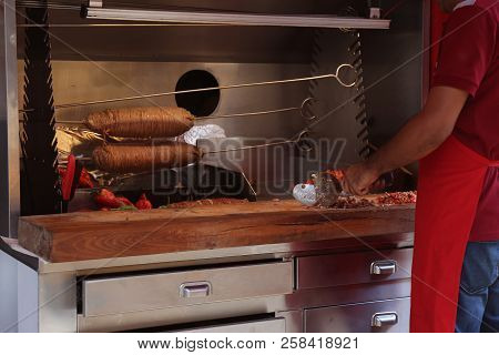 Man Cooking Delicious Kokoretsi At Table, Closeup