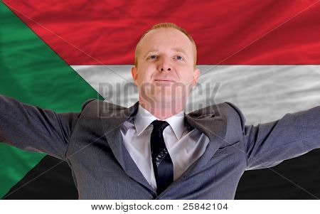Imprenditore felice a causa di un investimento redditizio In Sudan, in piedi vicino a bandiera