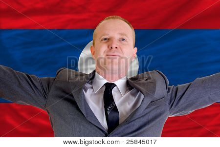 Imprenditore felice a causa di un investimento redditizio In Laos in piedi vicino a bandiera