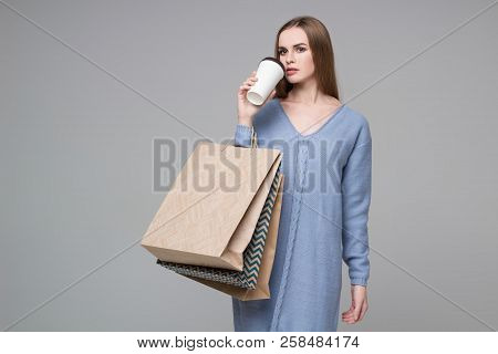 Girl In Blue Jamper Drinking Coffee With Paper Shopping Bags