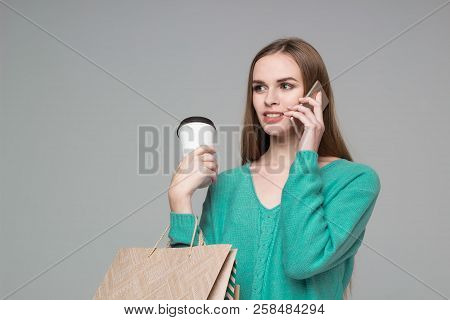 Girl In Green With Bags Drinking Coffee Talks By Smartphone