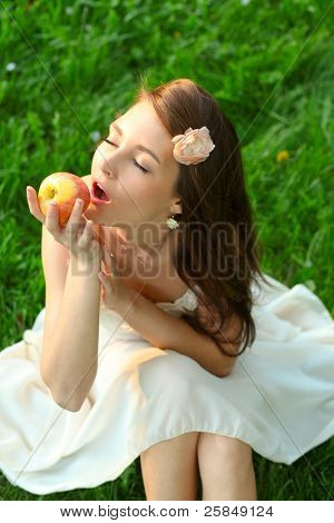 Rozkošný šťastná mladá dáma s krásnou sentimentální jablko zelené trávě