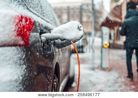 Electric Car Plug Charging In The Winter