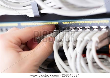 It Consultant Connects A Network Cable Into Switch In Large Datacenter