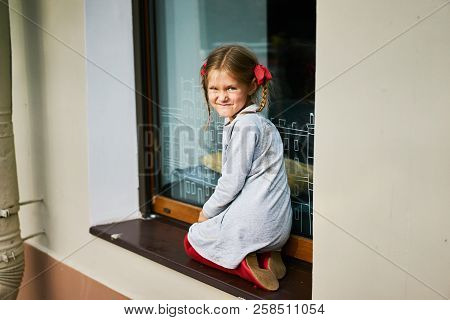 Girl Sitting On Big Window Squint Sun