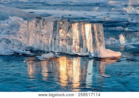 Ice Floe At Frozen Lake Surface With Reflection. Deep Cracks In The Ice And Ice Reflection