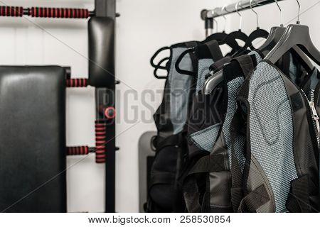Electrical Muscle Stimulation Vests Hanging On Rack In Gym