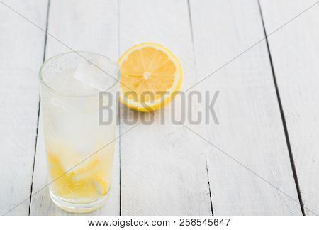 Lemon Juice Detox Water. Mineral Water Infused With Lemons. Wooden White Table.