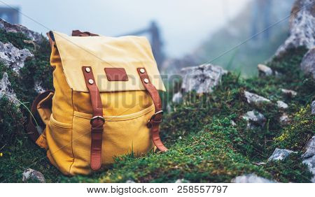 Hipster Hiker Tourist Yellow Backpack On Background Green Grass Nature In Mountain, Blurred Panorami