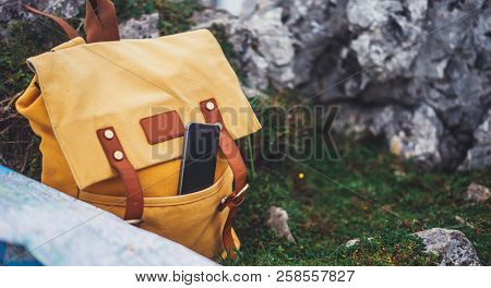 Hipster Hiker Tourist Yellow Backpack And Mobile Phone, Map On Background Green Grass Nature In Moun