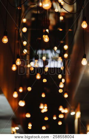 Burning Bulb Shines Weakly On The Background Blurred Yellow Lights