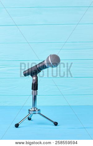 Microphone On Blue Wooden Background. Microphone On Short Rack Stand On Colored Wooden Surface. Mode