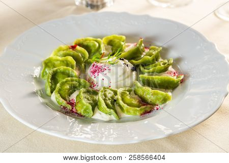 Homemade Green Dumplings With Potatoes And Spinach And Arugula Sour Cream On A Plate