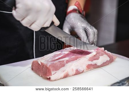 The Cook Cuts Raw Meat