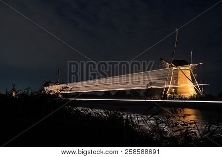 These Beautiful Windmills In Kinderdijk Are Illuminated With White Light At The Blue Hour