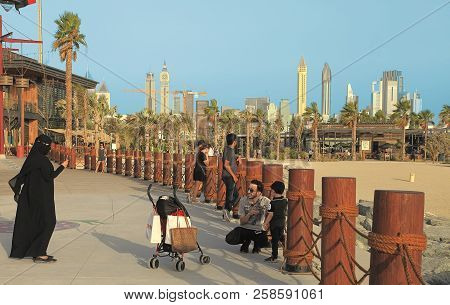 La Mer In Dubai, Uae - May 06, 2018: Muslim Woman Taking Pictures Of Her Child And Her Husband On Th
