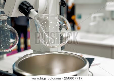 Glass Bulb Rotates In A Laboratory Evaporator. Industrial Background, Shallow Depth Of Field.
