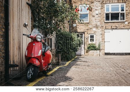 London, Uk - July 17, 2018: Red Vespa Motorbike Parked By A House In Dunworth Mews, Notting Hill. Ho