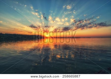 Amazing Sunset Over The River. Beautiful Clouds, Picturesque Sunbeams And Colorful Reflection In The