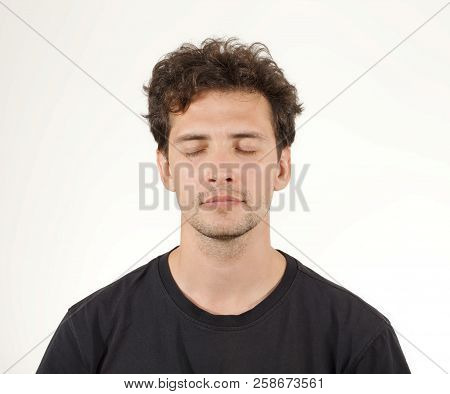 Young Brunette Man In Black Shirt Closing His Eyes