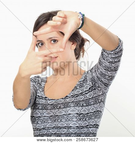 Nice Brunette Making Finger Frame Against White Wall