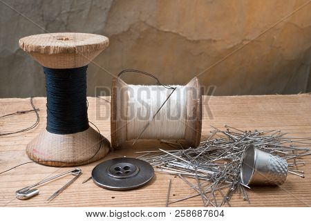 Two Spools Of Thread With Thimble On The Desk