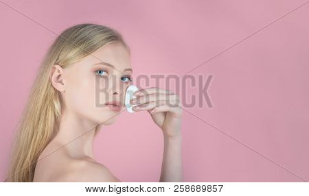 Girl Removes Makeup. Blonde Woman Holds Cotton Pad Near Face. Skin Care Products. Woman With Blue Ey